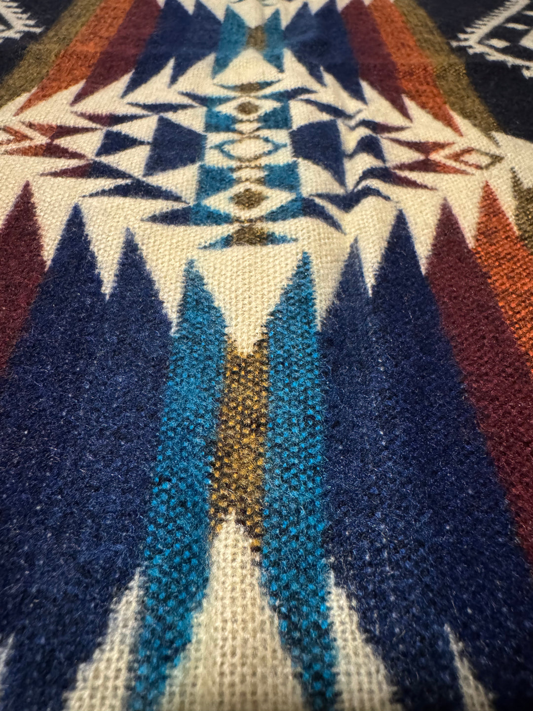 Cuzco Plaza de Armas Alpaca Wool Blanket featuring a colorful geometric Andean pattern in deep blue, gold, and cream tones.