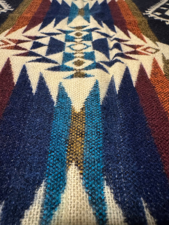 Cuzco Plaza de Armas Alpaca Wool Blanket featuring a colorful geometric Andean pattern in deep blue, gold, and cream tones.