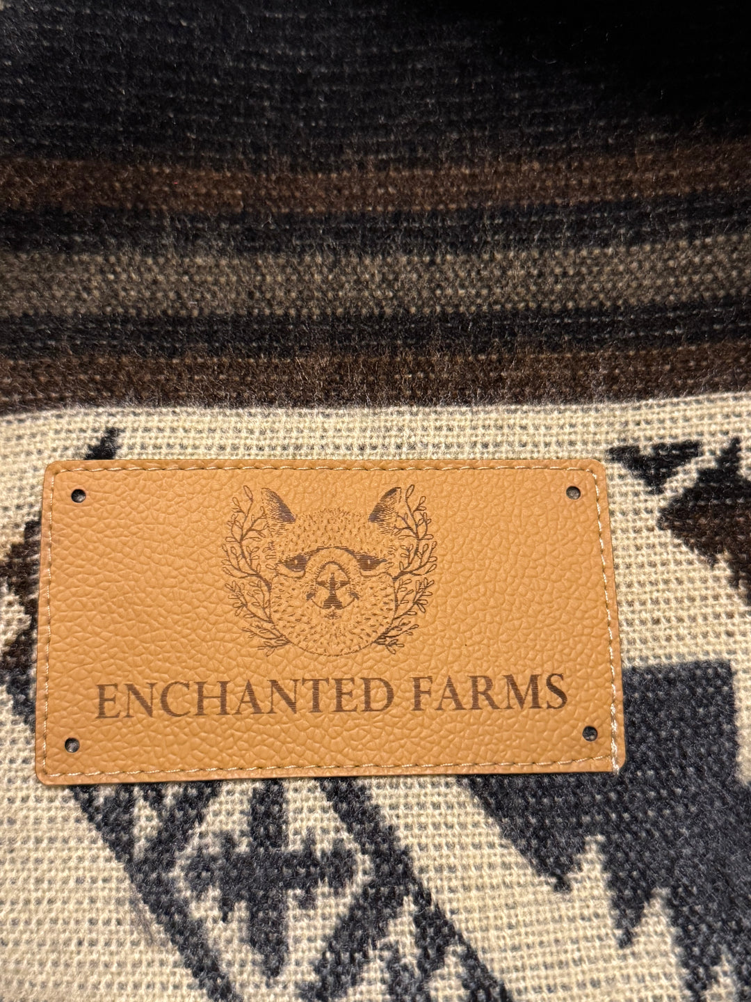 Leather Enchanted Farms label sewn onto the Cuzco Stone Alpaca Wool Blanket.